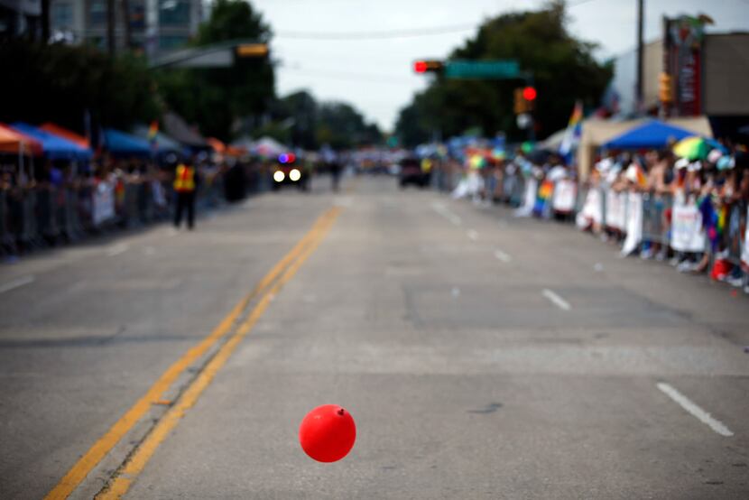 A lone balloon bounces along Cedar Springs Rd. before the Texas Freedom Parade begins,...