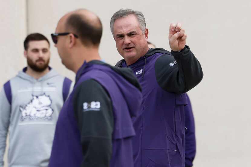 TCU coach Sonny Dykes does the Frogs' hand sign as he and other TCU football players,...