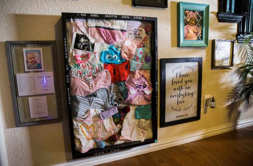 A shadow box containing items belonging to Anistyn Ragan hangs on the living room wall of...