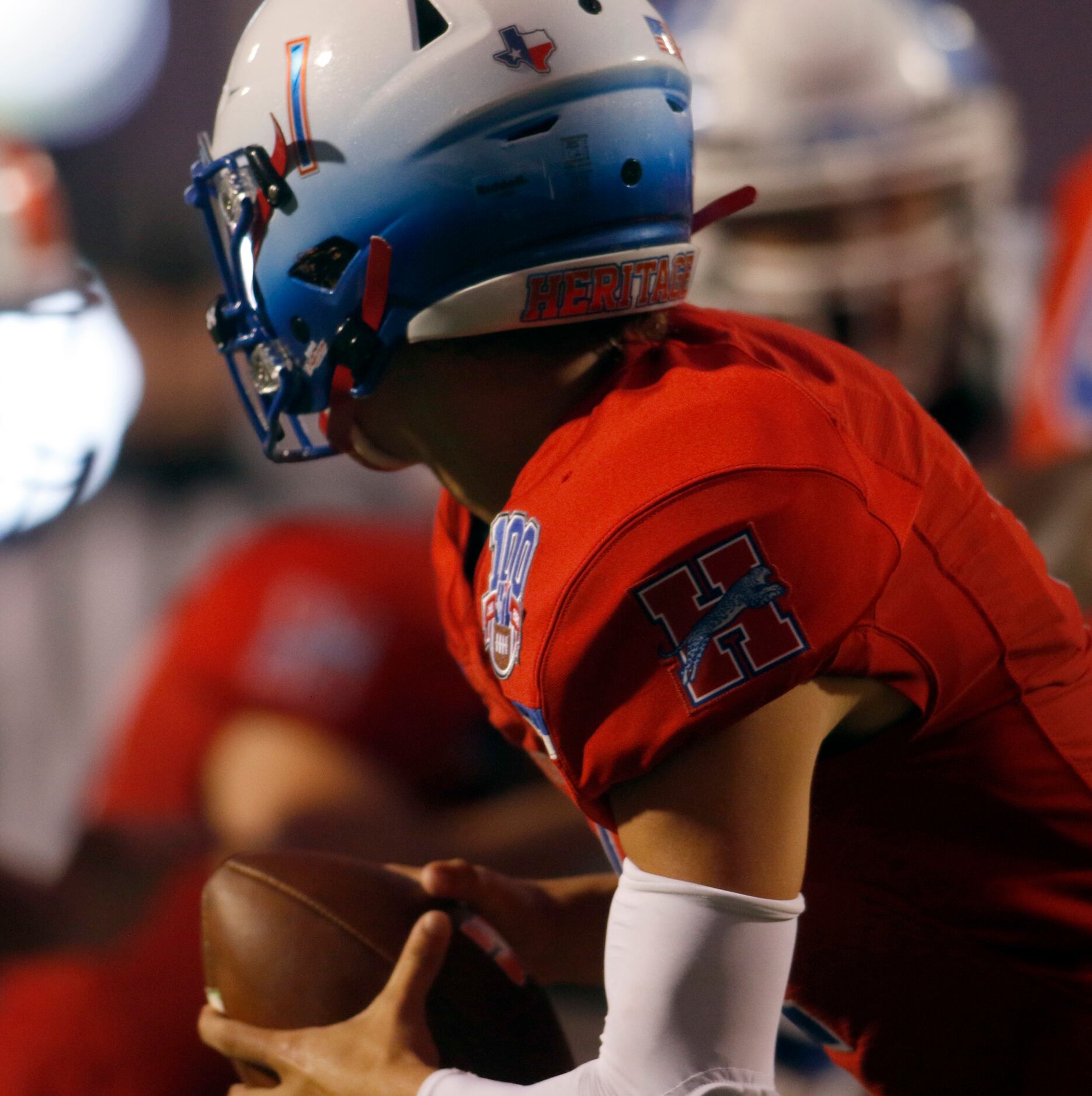 Midlothian Heritage quarterback Daelin Rader (1) rolls out to avoid pressure from the...