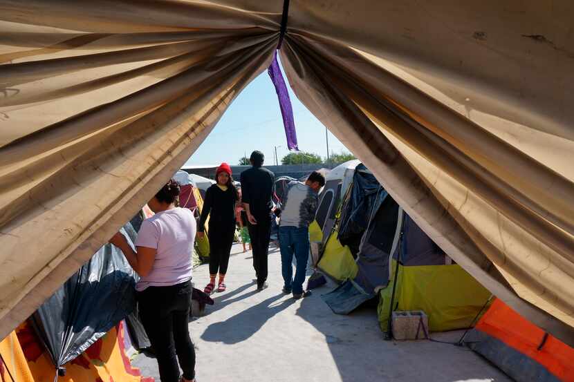 Migrants walk by their tents in the Senda de Vida 2 shelter in Reynosa, Mexico, Thursday.