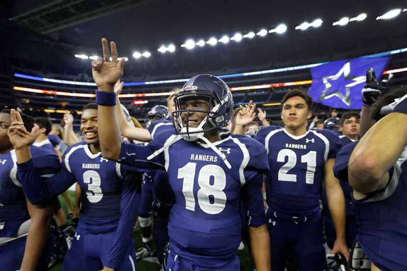 Frisco Lone Star quarterback Jason Shelley and his teammates listen to the school song...