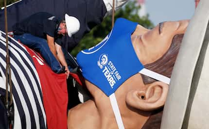 Up, up and away: Tim Thibodeaux works on the collar of Big Tex as he is prepared for...