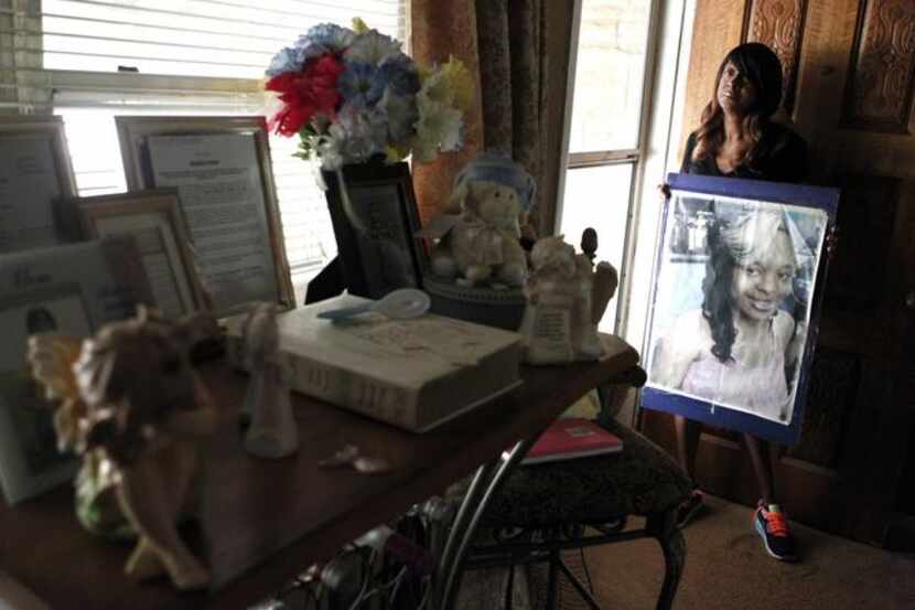 
Dianne Anderson holds a picture of her daughter, Breshauna Jackson, near the memorial...