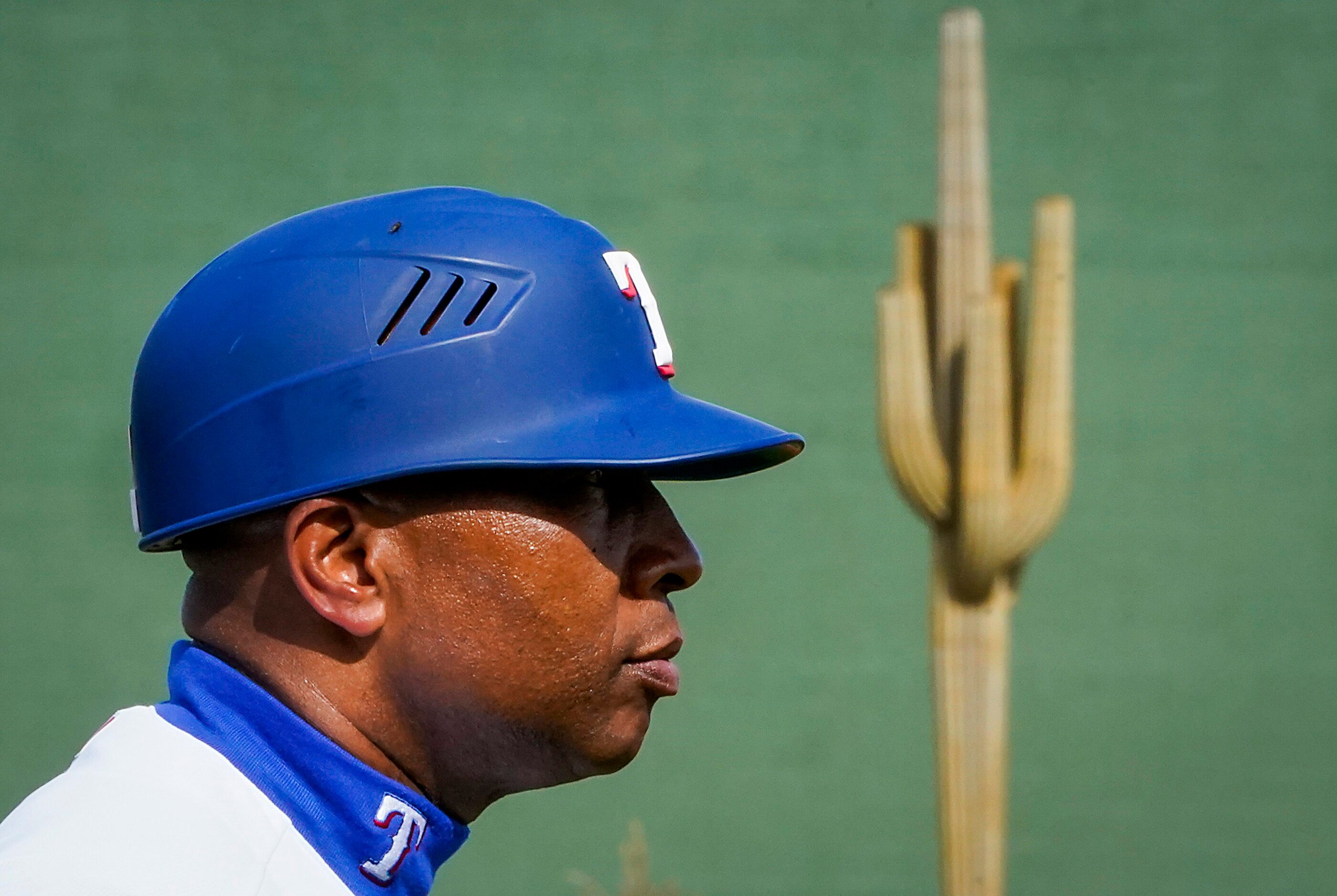 Texas Rangers third base coach Tony Beasley looks toward home as a large cactus is seen in...