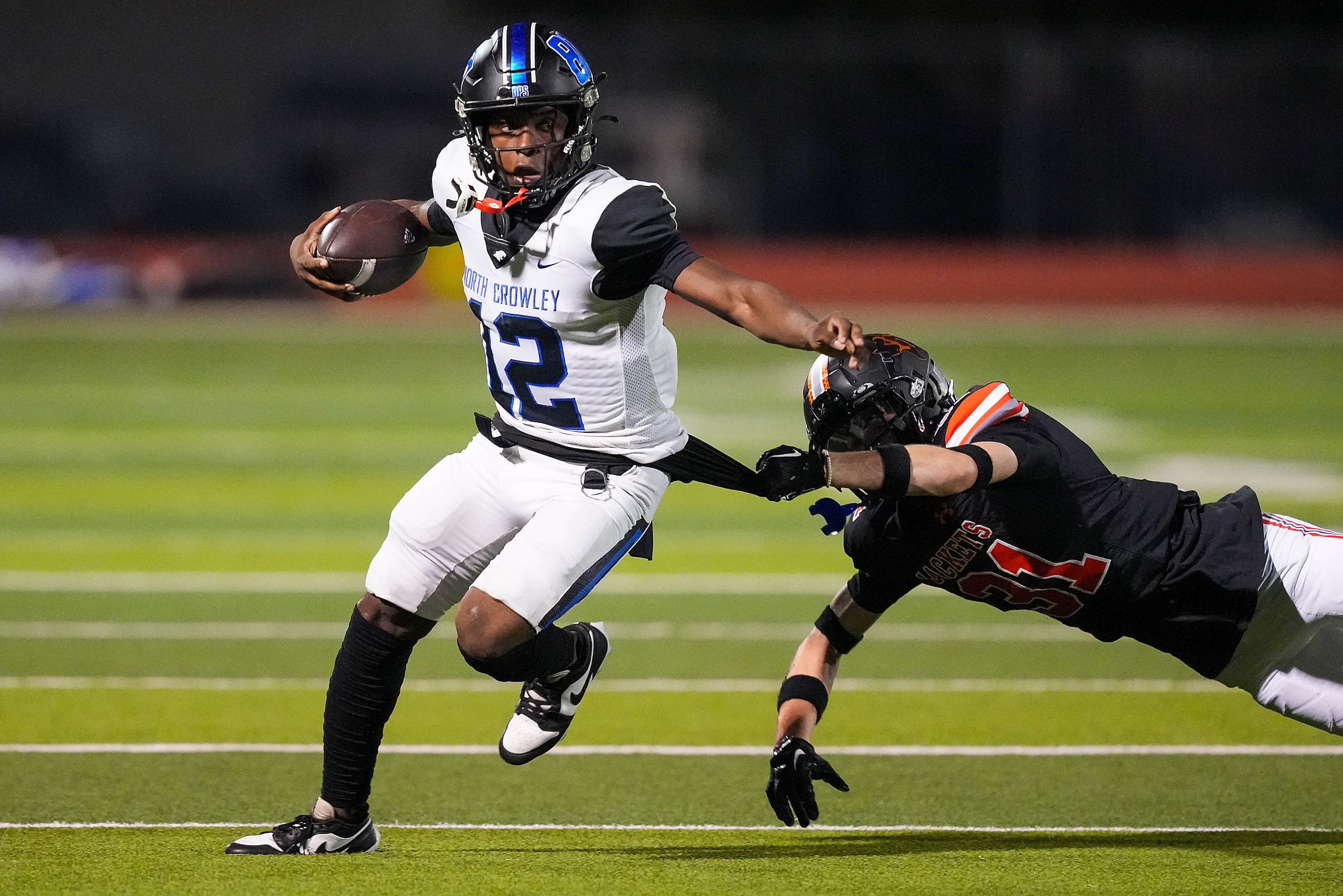 North Crowley quarterback Chris Jimerson Jr. (12) slips past Rockwall defensive back Landyn...