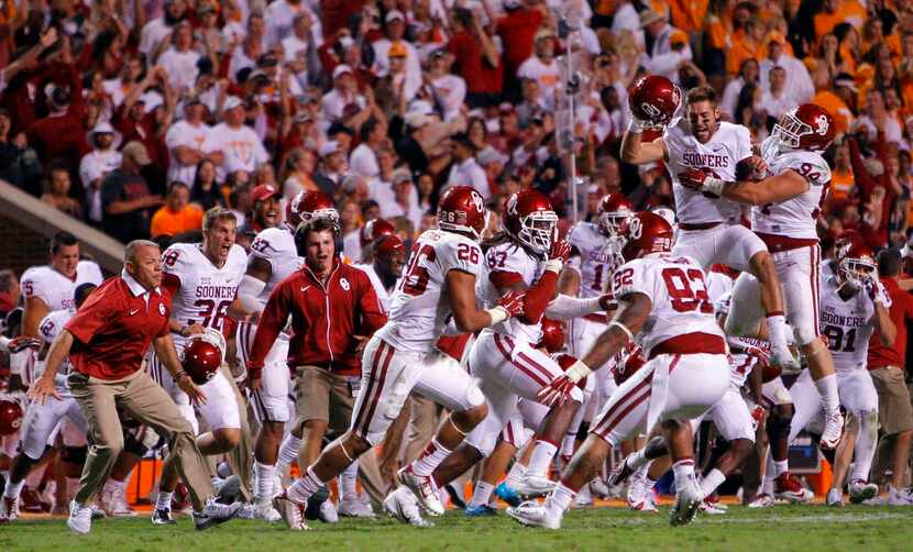 Oklahoma players celebrate a 31-24 double overtime victory in an NCAA college football game...