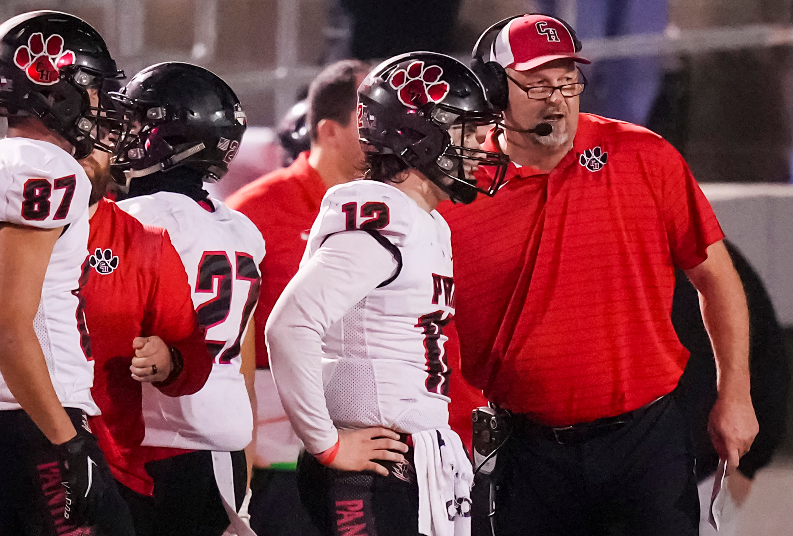 Colleyville Heritage head coach Kirk Martin talks with quarterback Luke Ullrich (12) on the...