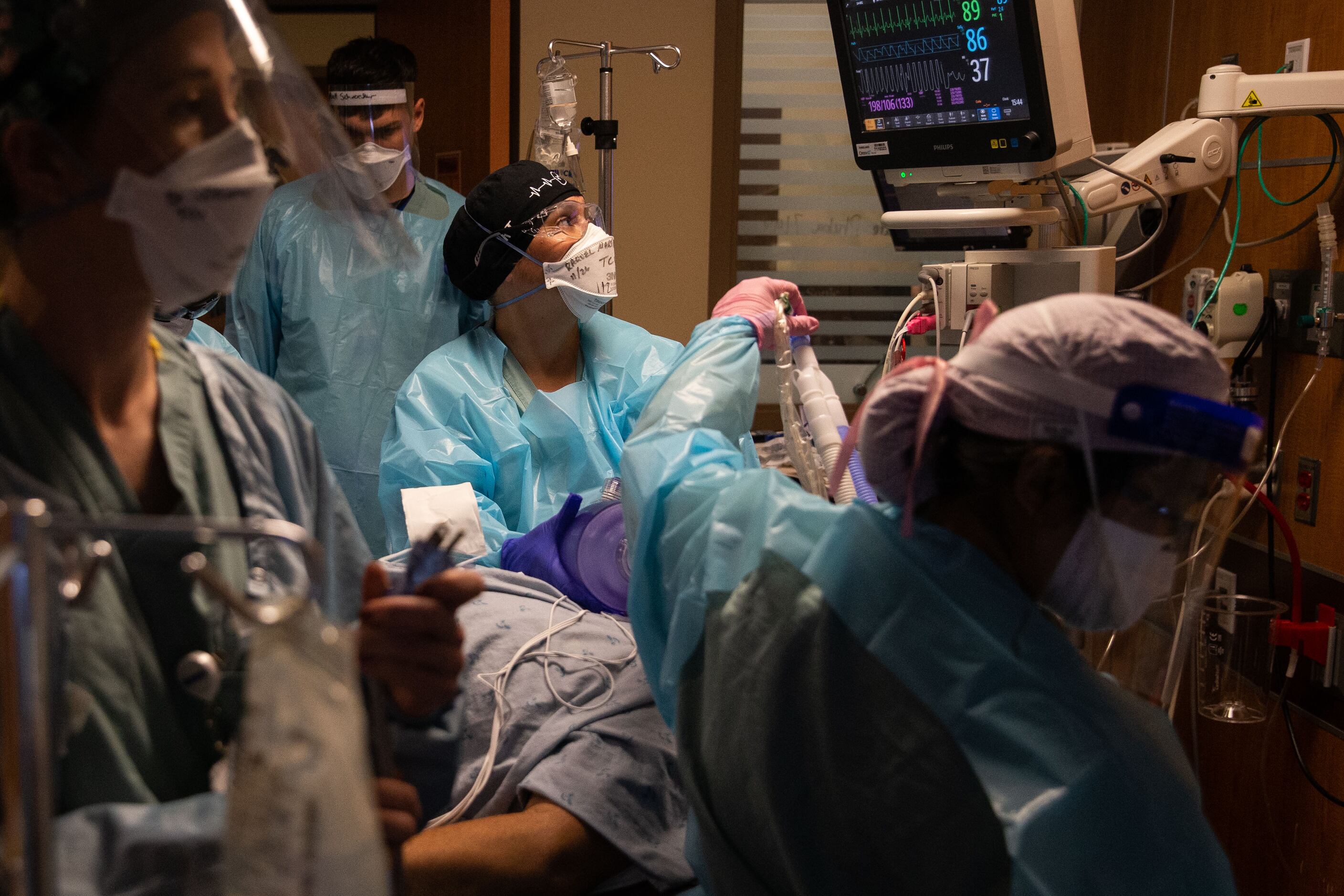 Martinez (center) monitors a patient’s vitals as he undergoes intubation to a ventilator in...