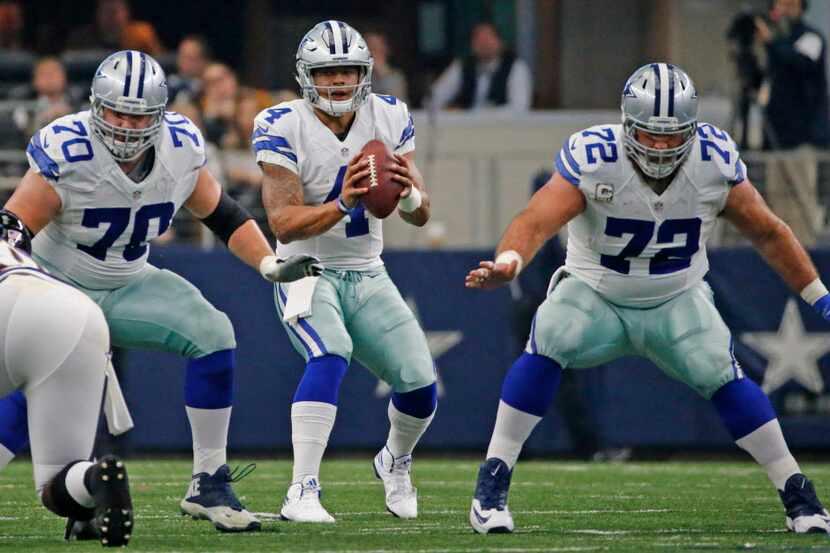 Dallas Cowboys quarterback Dak Prescott (4) takes the snap as guard Zack Martin (70) and...