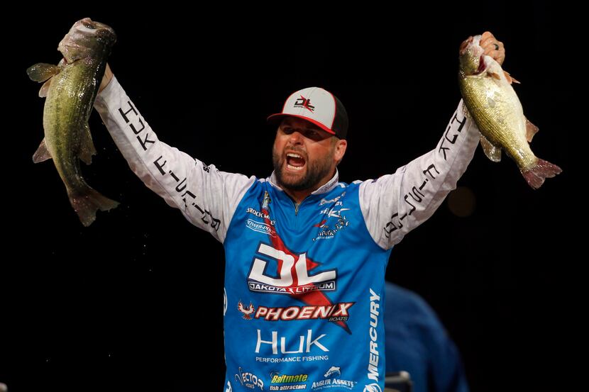 Brock Mosley lets out a yell while raising two of five fish he netted for a combined weight...