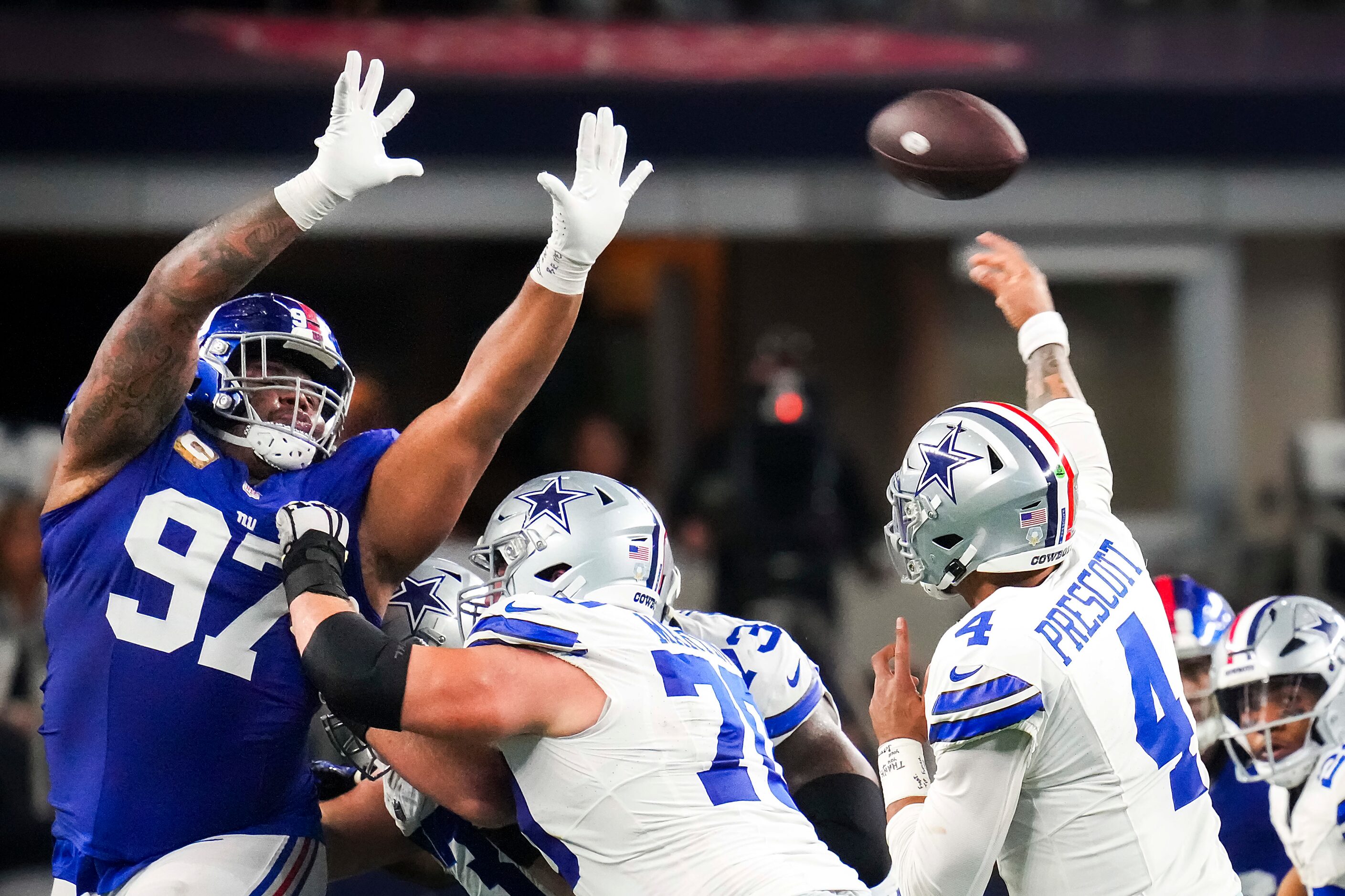 Dallas Cowboys quarterback Dak Prescott (4) throws a pass as guard Zack Martin (70) works...