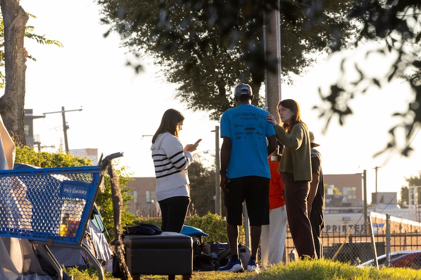 Haley Walton and Hannah Sims with Housing Forward speak to a person staying in encampment...