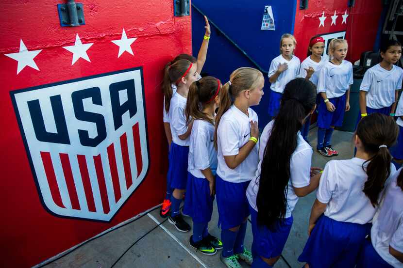 Young soccer players get their instructions before a friendly soccer game between the U.S....