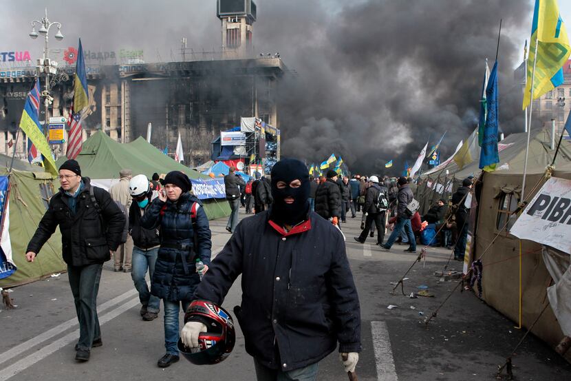 An anti-government protester walks away during clashes with riot police in Kiev's...