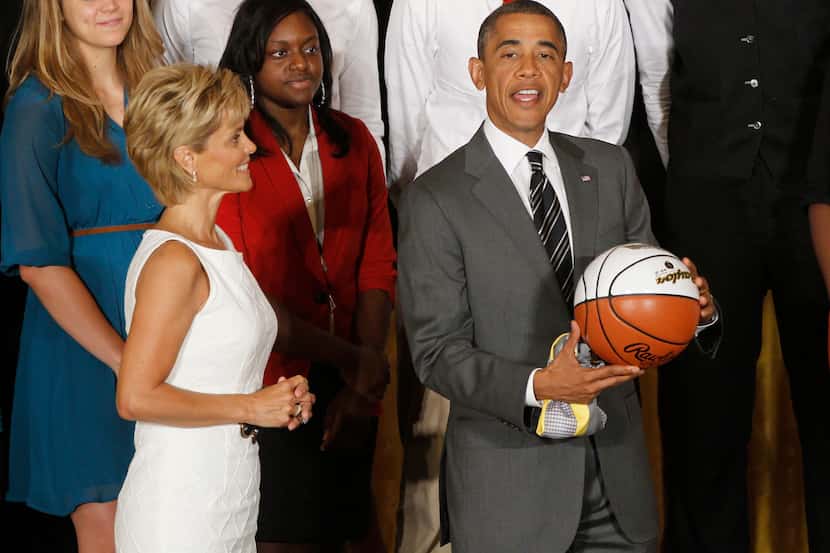 President Barack Obama stands with head coach Kim Mulkey as he is presented with a jersey...