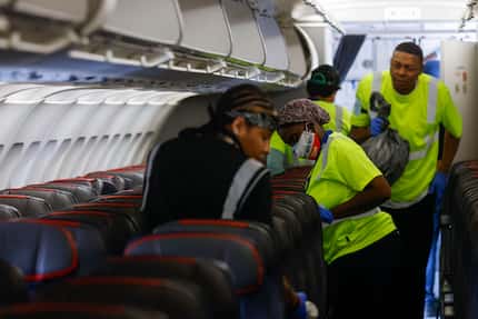 Cleaning workers work on an American Airlines flight from Grand Rapids, Mich., on Tuesday,...