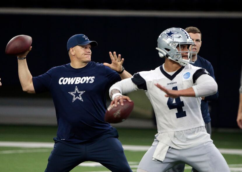 Dallas Cowboys quarterbacks coach Jon Kitna throws the ball alongside Dak Prescott (4)...