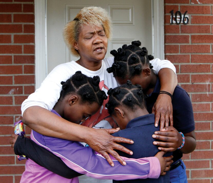 Paula Wooten prays with her grandchildren A'avryanna Wooten (left), 10, I'ivryanna Wooten...