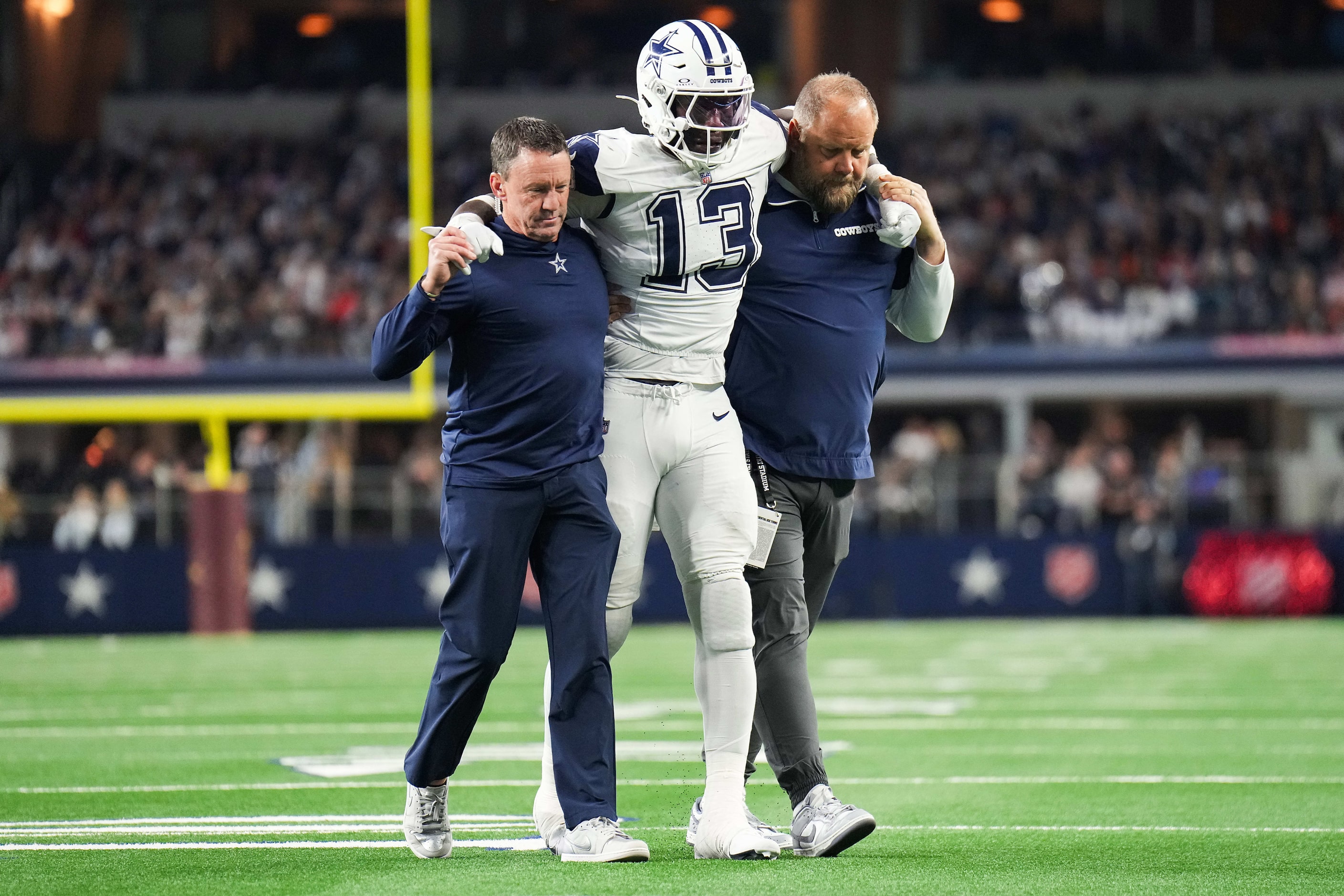 Dallas Cowboys linebacker DeMarvion Overshown (13) is helped off the field after being...