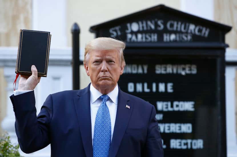 President Donald Trump holds a Bible as he visits outside St. John's Church across Lafayette...