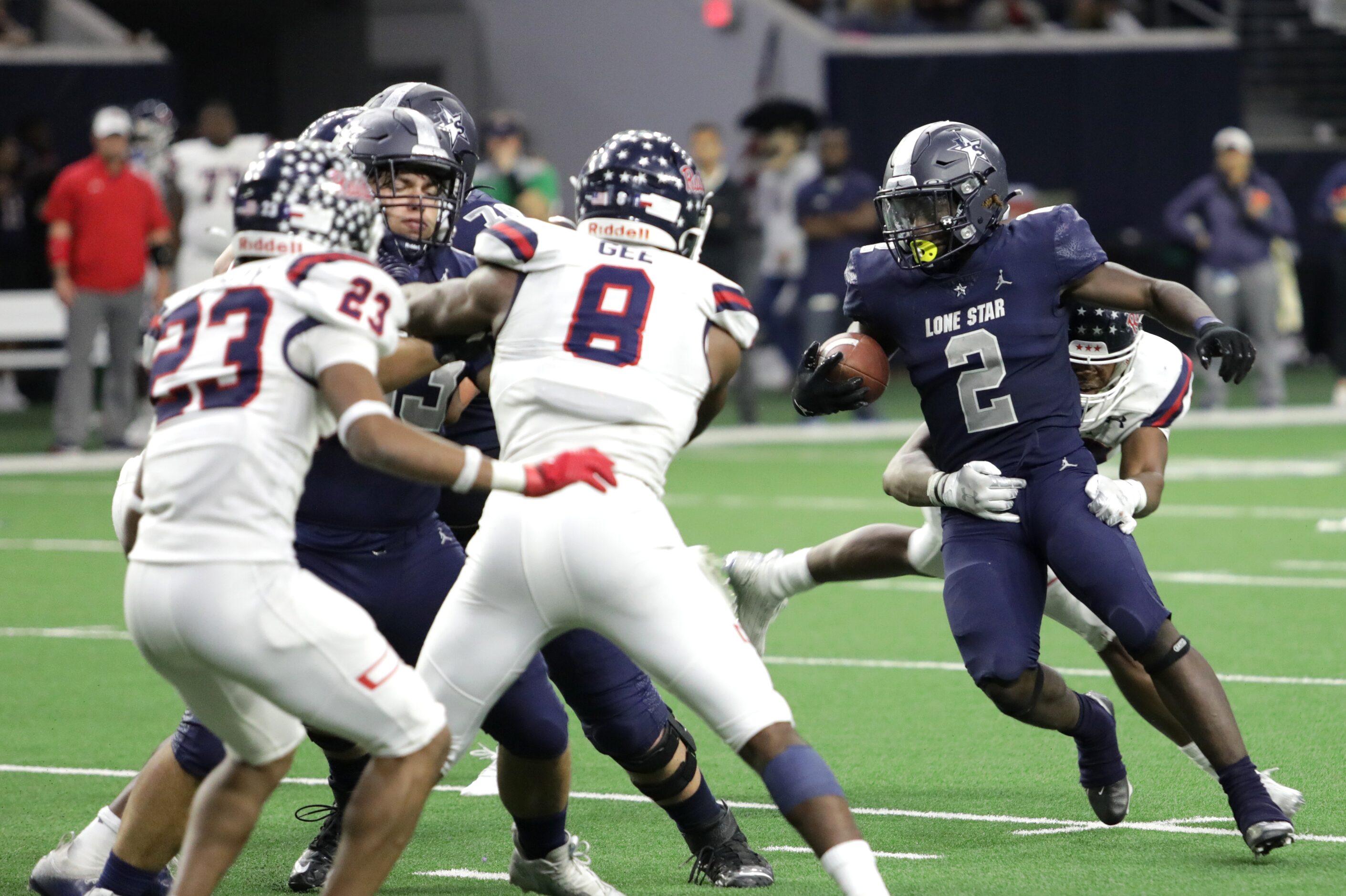 Lone Star player #2, Ashton Jeanty, tries to break a tackle by Ryan player #99, Ravonte...