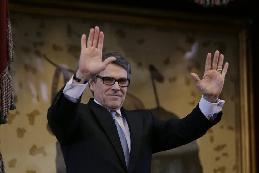 
Texas Gov. Rick Perry acknowledges applause as he arrives to give a farewell speech to a...