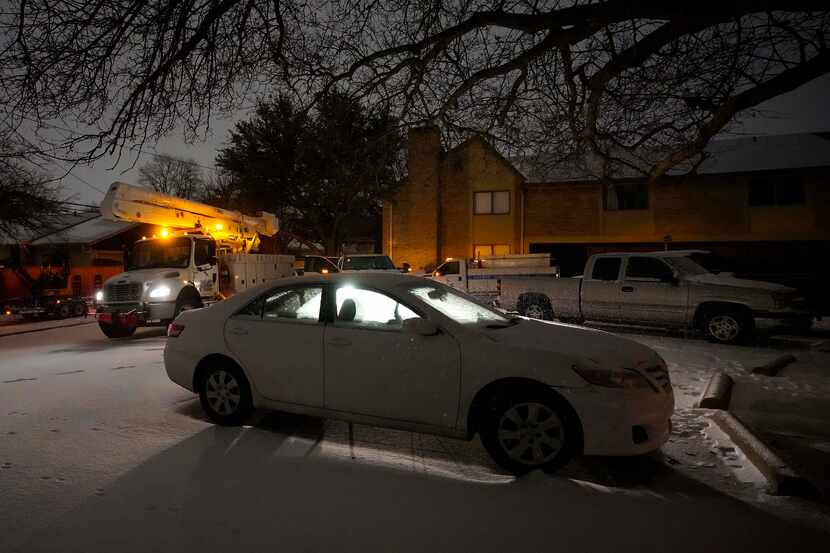 Power crews work in a darkened apartment complex after a second winter storm brought more...