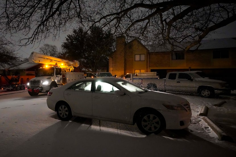 Power crews worked in a darkened Richardson apartment complex after a second winter storm...