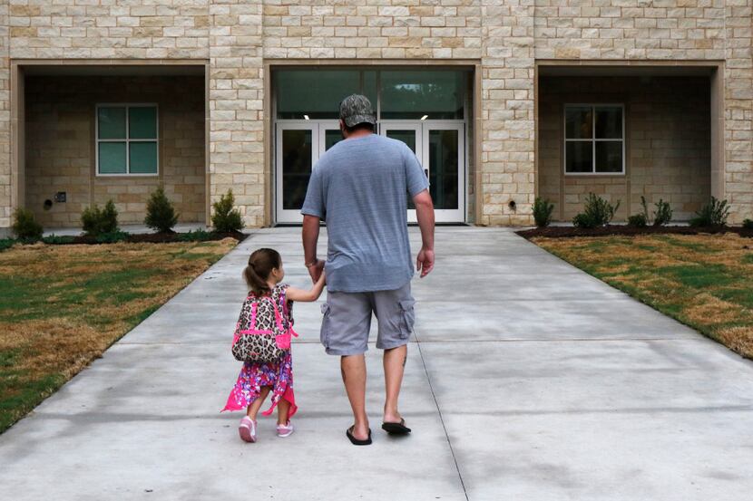 Brandon Crain walked his daughter Grace, 3, to her pre-K class on the first day of school at...
