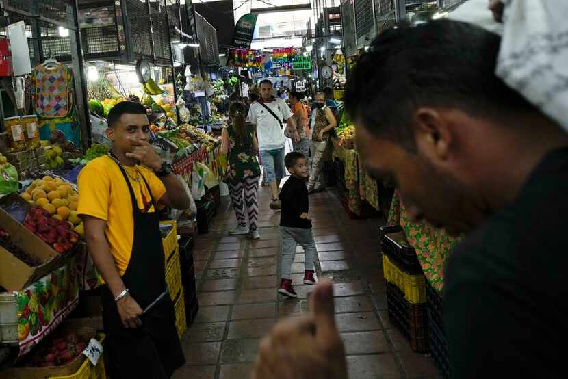 A boy runs runs down an aisle in a public market in the Quinta Crespo neighborhood of...