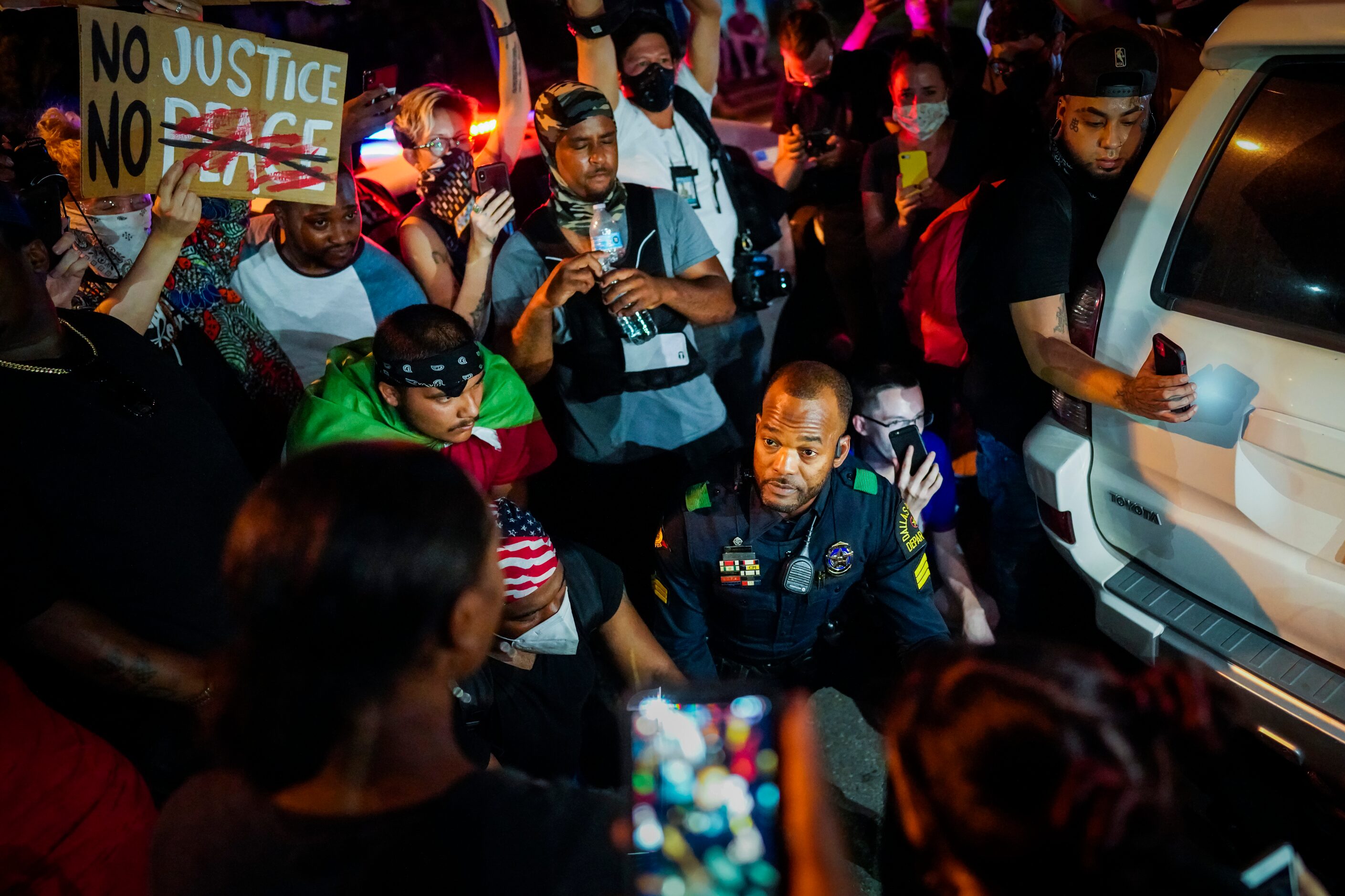 A Dallas police officer stops and gets our of his car to talk and take photos with a group...