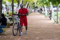 Allen Grant of Dallas pushes his bike while walking through Klyde Warren Park on Friday, May...