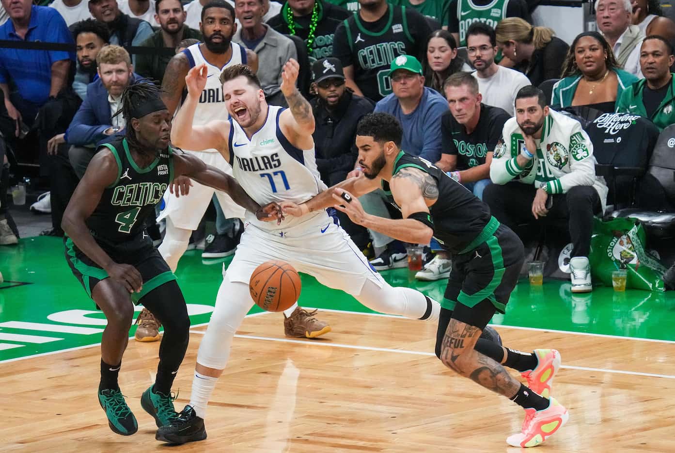 Dallas Mavericks guard Luka Doncic (77) loses the ball as Boston Celtics guard Jrue Holiday...