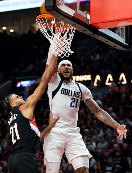 Dallas Mavericks center Daniel Gafford, right, dunks the ball against Portland Trail Blazers...