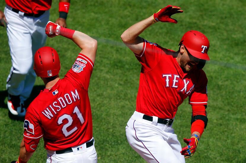 Texas Rangers right fielder Hunter Pence (right) is congratulated by teammate Patrick Wisdom...