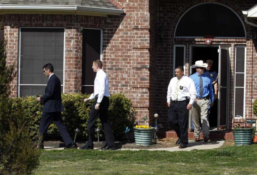 Law enforcement agents leave the home of Kaufman County District Attorney Mike McLelland and...