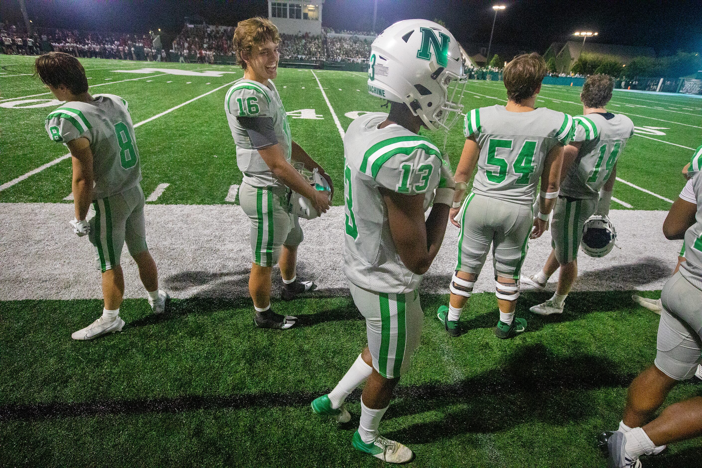 Arch Manning jokes with teammates as he watches the action from the sidelines as Newman High...