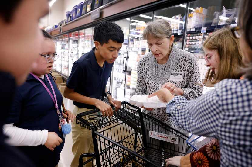 Uptown resident and Notre Dame School of Dallas volunteer Jeanie Essl shows students how to...
