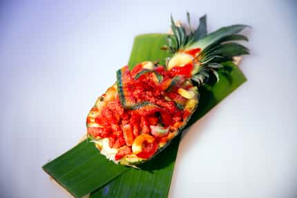 Rooftop bar 77 Degrees serves beachy food like this pineapple bowl filled with fruit, candy...