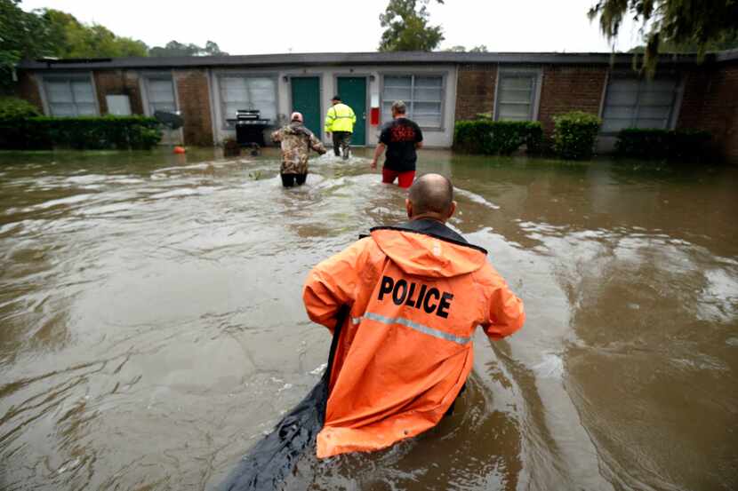 Volunteers assist police in making welfare checks on flooded homes in Dickinson, Texas, in...