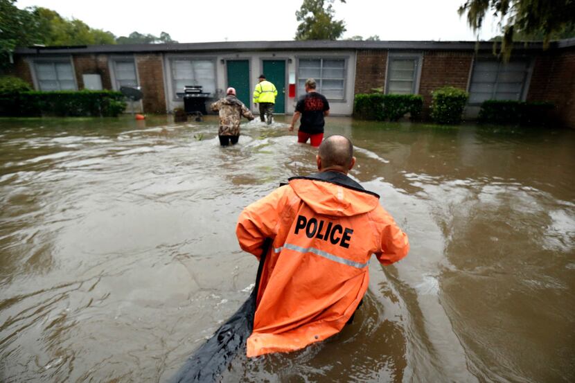 Volunteers assist police in making welfare checks on flooded homes in Dickinson in the wake...