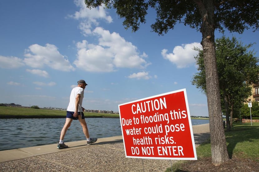 
Warning signs are posted near Lake Carolyn, which has been fouled after sewage spewed into...