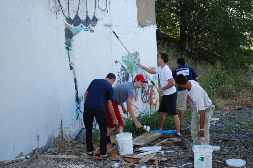 Members of Keep Carrollton Beautiful painted over graffiti at a site in the northern part of...