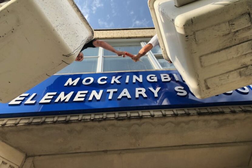 Workers install a new sign above the entrance of Dallas ISD's Stonewall Jackson Elementary,...
