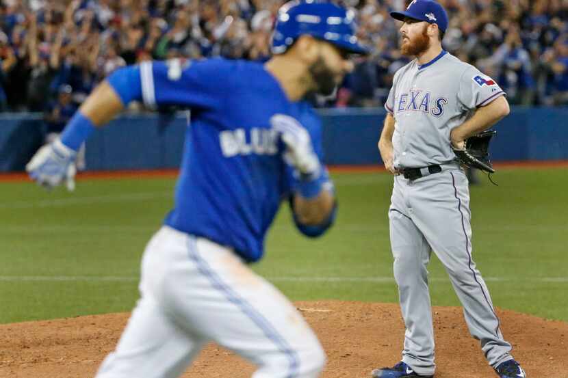 Toronto Blue Jays Jose Bautista, left, circles the bases after hitting a three-run homer off...