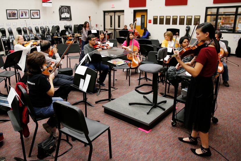 Assistant director of orchestra Victoria Lien leads a practice for parents of students at...