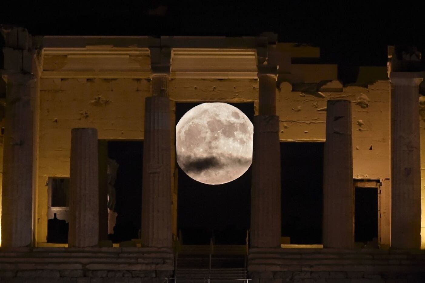 The 'Supermoon' rises behind the Propylaea above the Ancient Acropolis hill in Athens on...