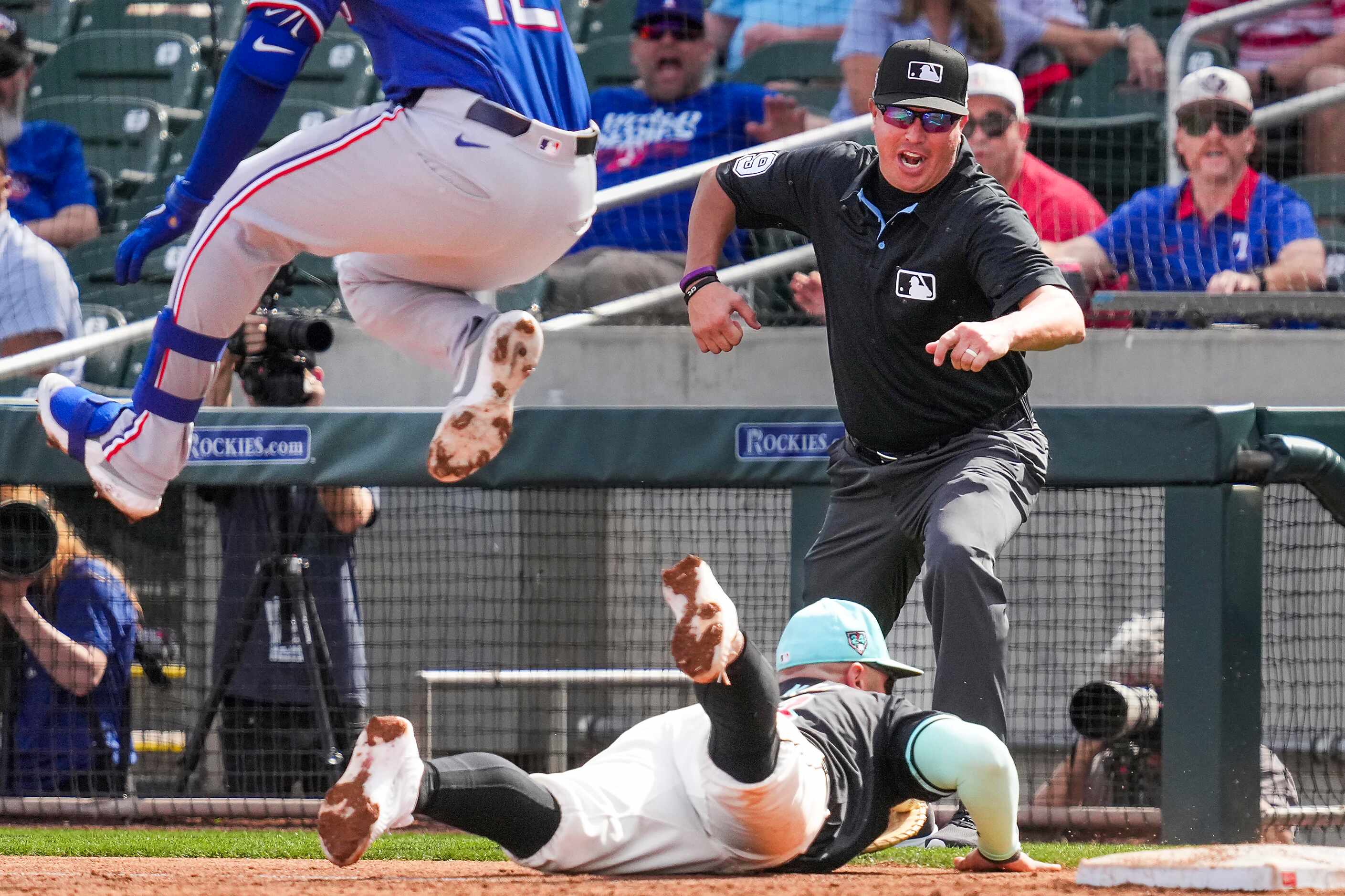 Umpire Cory Blaser makes the call as Texas Rangers designated hitter Andrew Knizner is out...