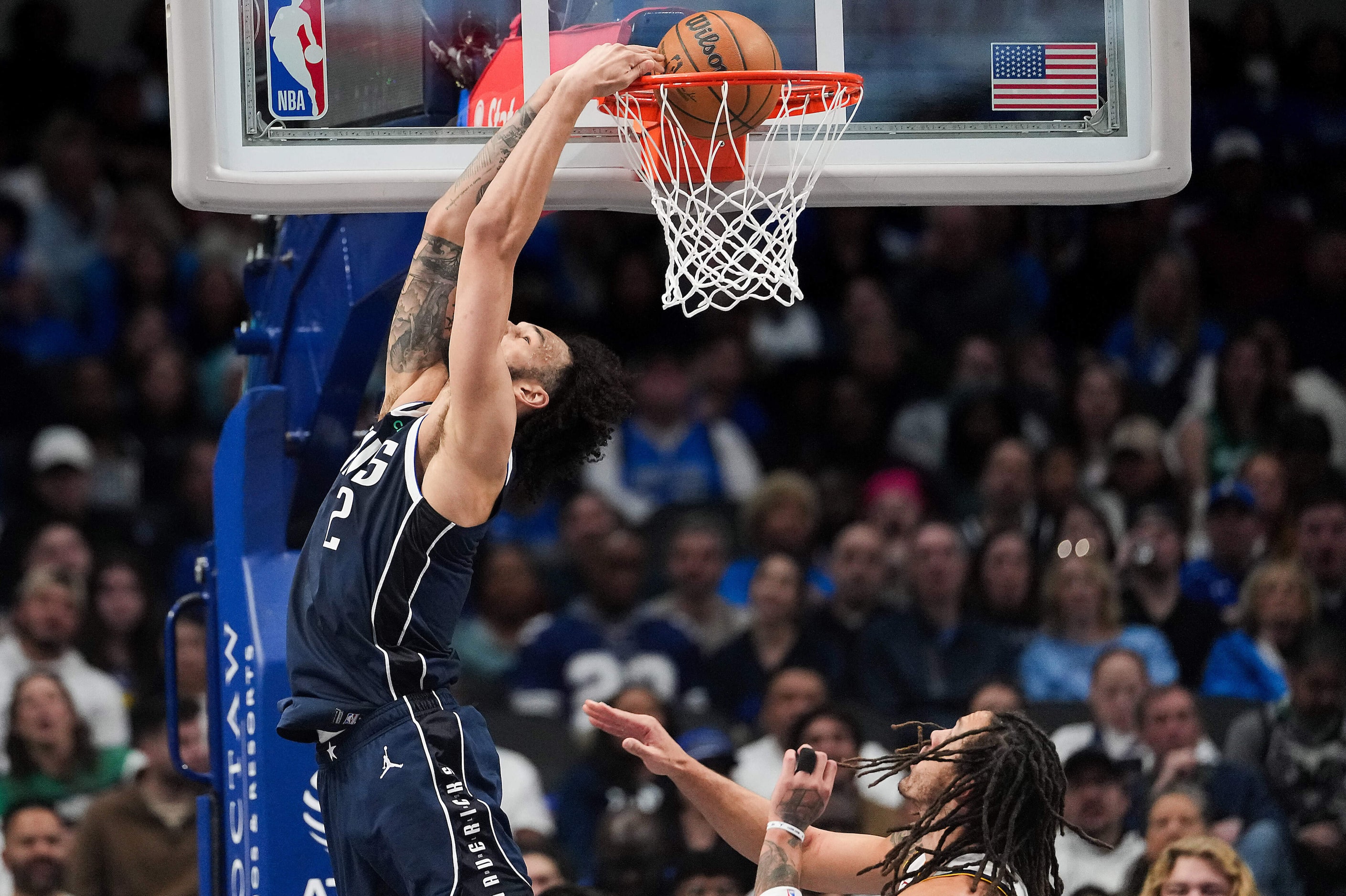 Dallas Mavericks center Dereck Lively II (2) dunks the ball past Denver Nuggets forward...